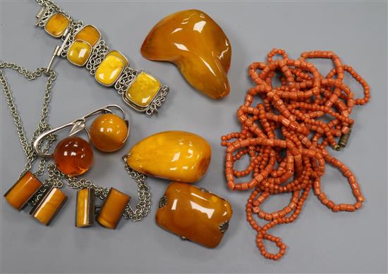 A white metal and amber bracelet, three amber brooches, two amber pendants, amber cufflinks and two coral necklaces.